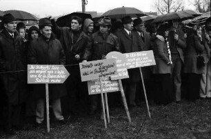Sasbach: Kundgebung gegen Bleiwerk Marckolsheim und Atomkraftwerk Wyhl; Protestwehrversammlung im Regen mit Plakaten