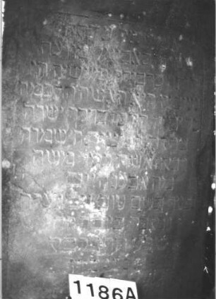 Grabstein 1186 (Index: 99899931) Material: Sandstein Zustand: stark verwittert Maße HxBxT: 151x77x10 cm Beschreibung: Stele mit abgeflachtem Dreiecksabschluss: Grabstein 1186A