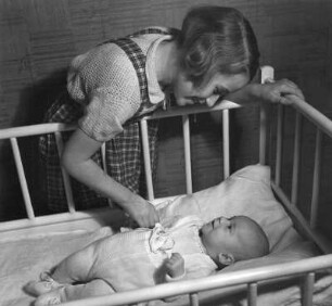 Kinderbilder. Mädchen am Bett eines Säuglings, vermutlich eines Geschwisterkindes