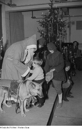 Weihnachtsmann, einem kleinen Jungen ein Geschenk überreichend