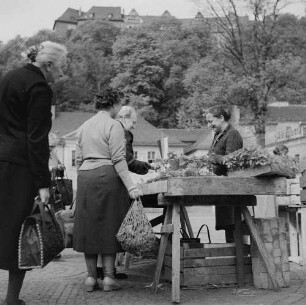 Greiz. Frauen stehen an einem Gemüsestand auf dem Wochenmarkt