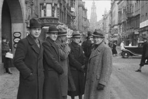 Dresden, Schloßstraße : Dresden. Eine Gruppe junger Männer (vielleicht Teilnehmer eines Kurses). Im Hintergrund der Turm der Katholischen Hofkirche