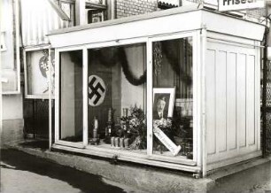 Dresden, Altenberger Platz. Schaukasten mit Porträtfoto Adolf Hitlers, Hakenkreuzfahne, Zinngefäßen und Blumen als Werbung für Metallsammlung
