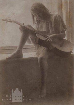 Auf dem Fensterbrett sitzendes Mädchen mit Gitarre