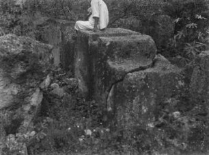 Alte Mauer : Ein Mann sitzt auf Ruinen.
