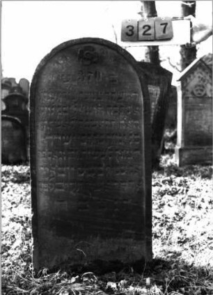 Grabstein 327 (Index: 100115823) Material: Sandstein Zustand: verwittert mit geringem Textverlust Maße HxBxT: 114x57x14 cm Beschreibung: Stele mit Rundbogenabschluß, eingetieftes Schriftfeld Symbolik: Blüte: Grabstein 327