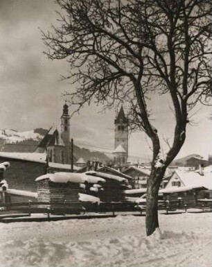 Kitzbühlel. Tirol. Österreich. Winter. Blick auf den verschneiten Ort. Links im Bild die spätgotische-barocke Stadtpfarrkirche "Zum heiligen Andreas". Rechts die im 14. Jh. im gotischen Stil errichtete Liebfrauenkirche