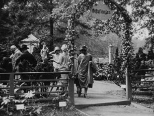 Szene aus dem Dokumentarfilm "Bilder von der Frühjahrsblumen-Eröffnungsschau der Jubiläums-Gartenbau-Ausstellung": Besucher auf dem Ausstellungsgelände