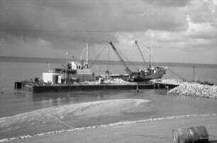 Eiderstedt: Eiderdamm, Bauinsel [für das Eidersperrwerk], Schwedengranitschiff beim Entladen