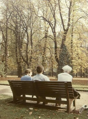 Dresden. Spaziergänger auf einer Parkbank im Großen Garten