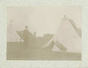 Kurt von Breuning in Uniform mit Mütze im Zeltlager von Münsingen zwischen Zelten stehend