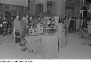 Besucher an einer Produktionsmaschine in der sowjetischen Ausstellungshalle (Sowjetischer Pavillon)