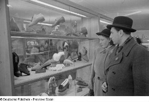 Besucher vor einer Vitrine mit Schuhmodellen