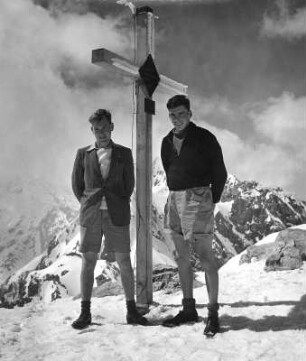 Tirol. Zwei junge Männern neben dem Gipfelkreuz auf dem Hafelekar (2269 m)