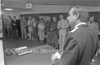 Raiffeisenbank: Vernissage "100 Jahre Musikzug der Freiwilligen Feuerwehr Reinfeld": Wehrführer Werner Gaethke bei der Eröffnungsrede vor Zuhörern: vorne links Rednerpult mit Buch und Stift: im Hintergrund Bankschalter