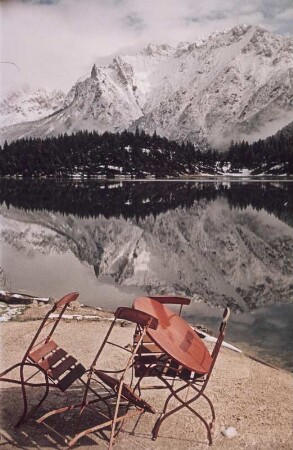 Mittenwald. Stühle auf einer Terrasse eines Restaurants an einem Bergsee