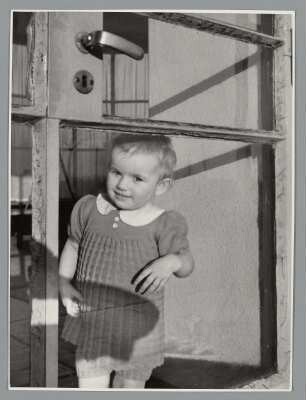 Portrait eines Kleinkindes durch ein Fenster blickend