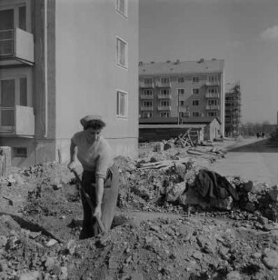 Dresden. Frau beim Arbeitseinsatz vor neu gebauten Wohnblöcken