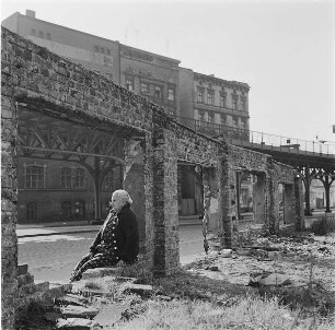Ruine am U-Bahnhof Schlesisches Tor. Frau im ehemaligen Schaufenster sitzend