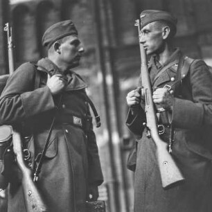 Wehrmachtssoldaten mit Schiffchen und Gewehr, Soldaten auf Urlaub