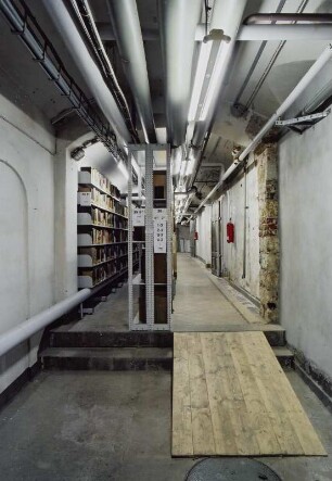 Sächsische Landesbibliothek - Staats- und Universitätsbibliothek Dresden. Zentralbibliothek (ehem. Landesbibliothek). Kellergeschoss. Gang mit Heizungsrohren und Kabeltrasse. Mitnutzung durch Abteilung Benutzung als Magazin : Dresden-Neustadt, Marienallee 12. Sächsische Landesbibliothek - Staats- und Universitätsbibliothek Dresden. Zentralbibliothek (ehem. Landesbibliothek). Kellergeschoss. Gang mit Heizungsrohren und Kabeltrasse. Mitnutzung durch Abteilung Benutzung als Magazin