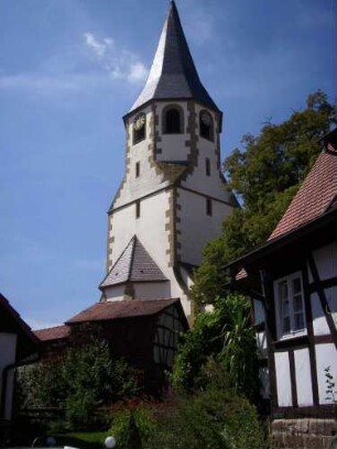 Ansicht von Nordosten mit Kirche (Chorturm mit Schlitzfenstern im Mittelgeschoß sowie achteckiger Glockenstube) über Kirchhofmauer