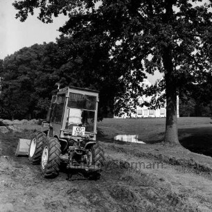 Schlosspark: Erdarbeiten: Baggerlader beim Abschieben von Boden: dahinter äußerer Schlossgraben, Baum: hinten Schlossinsel, Schloss