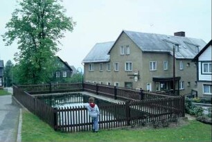 eingezäunter Löschteich, Häuser