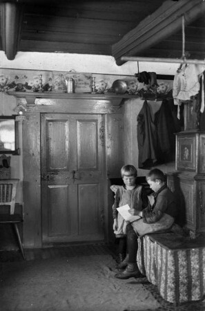 Bauernstube mit Kinder auf der Ofenbank