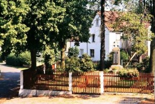 umzäuntes Areal mit dem Denkmal für die Gefallenen der beiden Weltkriege (25 bzw. 29 Tote!)