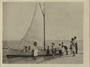 An der See. Ein Segelschiff wird für die Abfahrt vorbereitet. Die ersten Passagiere befinden sich schon an Bord