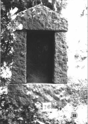 Grabstein 33 (Index: 99805404) Material: Granit, schwarze Marmorplatte Zustand: gut, Schriftplatte unbeschriftet Maße HxBxT: 148x73x19 cm Beschreibung: ädikulaartige Stele, Sockel, giebelartiger Abschluß, rechteckige Schriftplatte: Grabstein 33