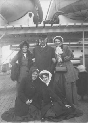 Hochseepassagierdampfer Pennsylvania, Bordaufnahmen. Gruppenbild mit vier Damen und einem Herren in winterlicher Kleidung unter den Rettungsbooten an Deck der Pennsylvania
