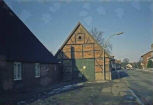 Alte Landstraße [34]: traufständige Durchfahrtsscheune, Fachwerkbau: Giebelseite mit Scheunentor: links traufständiges Bauernhaus [angeschnitten]