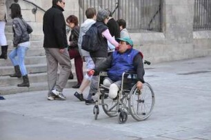 Barcelona - Behinderter im Rollstuhl bettelt : Vor der Kathedrale sitzt ein behinderter Mann in seinem Rollstuhl und bettelt Passanten an. Aufgenommen am 15. April 2012 in Barcelona