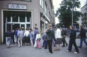 Berlin-Mitte, Rosenthaler Platz. Warteschlange vor einem "A & V" Laden für An- und Verkauf gebrauchter Industriewaren