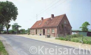 Altfresenburg 8: traufständige Landarbeiter-Doppelkate, Backsteinmauerwerk: Straßenfront mit Eingangstüren, Giebelseite: rechts Schuppen