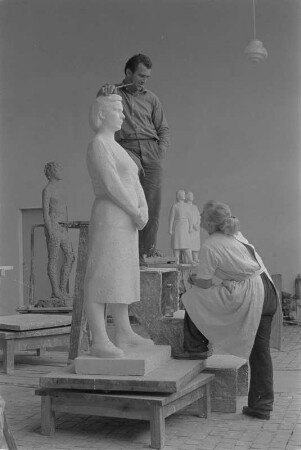 Beim Modellieren einer stehenden Frau mit verschränkten Händen. Gips (1960/1962) (Studentenarbeit der Bildhauerklasse von Walter Arnold)