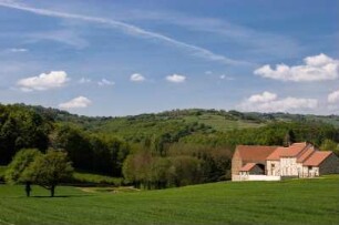 Frankreich. Auvergne. Allier. Chouvigny. Restaurierter Bauernhof in typischer Huegellandschaft