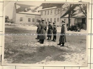 Angehörige der Ordnungspolizei auf einem Innenhof vor einem Gebäude