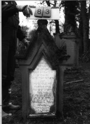 Grabstein 83 (Index: 100100419) Maße HxBxT: 118x46x21 cm Besonderheit: kulturhistorisch wertvoll / hist.-wiss. Gründe (Gemeindestellung): Grabstein 83