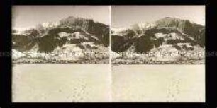 Winterlandschaft mit Blick auf Ortschaft und Gebirge