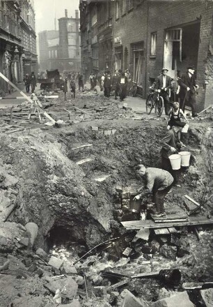 Hamburg-Neustadt. Wasserversorgung aus einer geborstenen Leitung in der Neustädter Straße, Ecke Breiter Gang, gesehen in östlicher Richtung hinüber zur Kaiser Wilhelm Straße