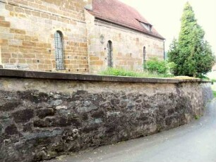 Ansicht von Nordosten mit Kirchhofmauer über Ortsseite im Verlauf nach Westen-Werksteine im Mauersteinverband-Wehrgang mit Steinbrüstung im 18 Jh abgetragen