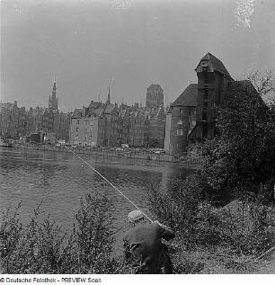 Danzig. Blick auf die Rechtsstadt mit Krantor und über den Fluss Mottlau, im Vordergrund ein Angler