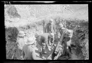 Übungsgelände I bei Mouzon (Dep. Ardennes, Frankreich): Soldaten mit Stahlhelm in einer Grube bei Beladen eines ("Minenwerfer[s]?") (Blick vom Grubenrand)