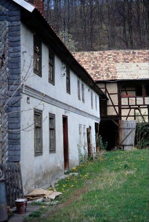 Blick in einen Zweiseithof; links Wohnhaus, hinten Scheune mit Laubengang; Hoffläche unbefestigt