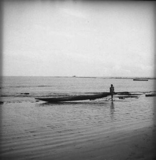 Zu Wasser lassen des Bootes : Ein Fischer schiebt sein Boot über den Strand ins Wasser.