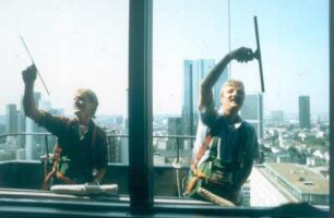 Frankfurt (Main). Fassadenreiniger bei der Arbeit. Blick aus einem Büroraum der SGZ-Bank