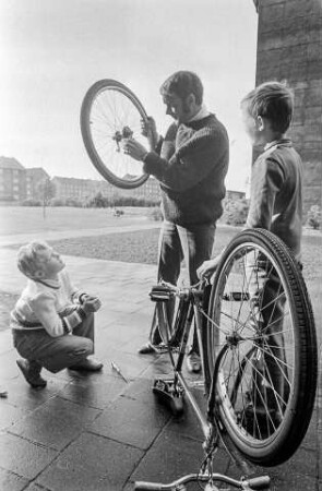 Familie bei Fahrradreparatur, 1975. SW-Foto © Kurt Schwarz.